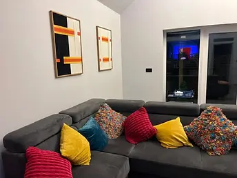 Comfortable corner sofa and colourful cushions in the lounge at Lydden Bell Lodge