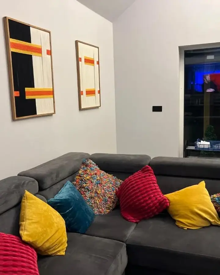 Lounge with a charcoal corner sofa and colourful cushions at Lydden Bell Lodge