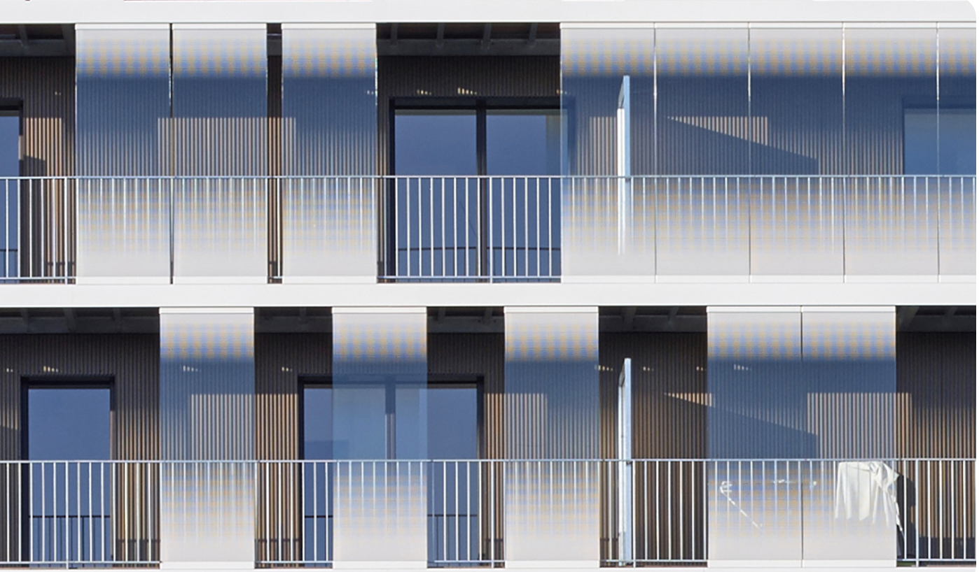 An apartment elevation of glazed balcony enclosures with etched glass panels between slatted timber bays