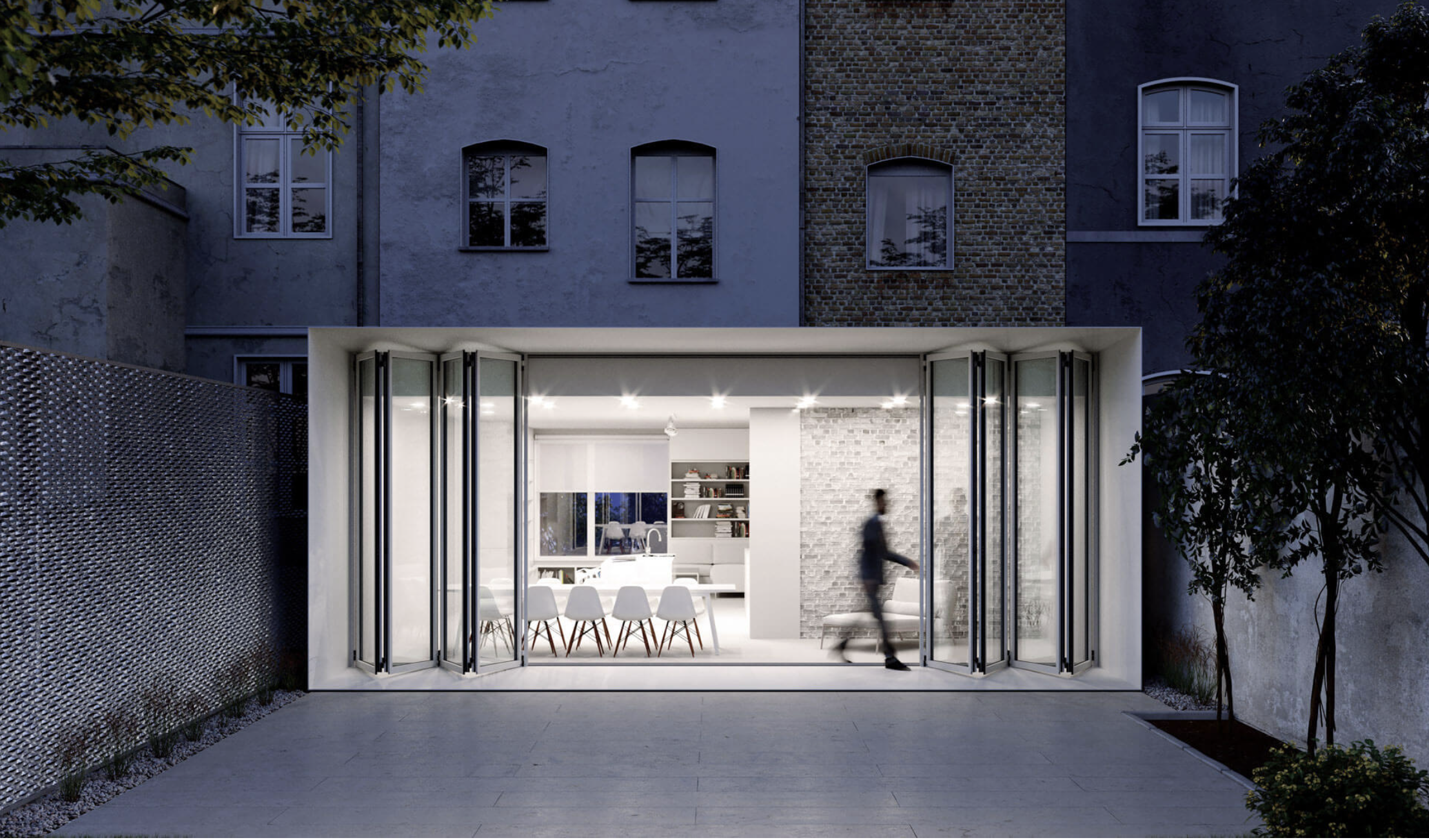 Solarlux bi-folding doors folded open on a glazed extension at dusk