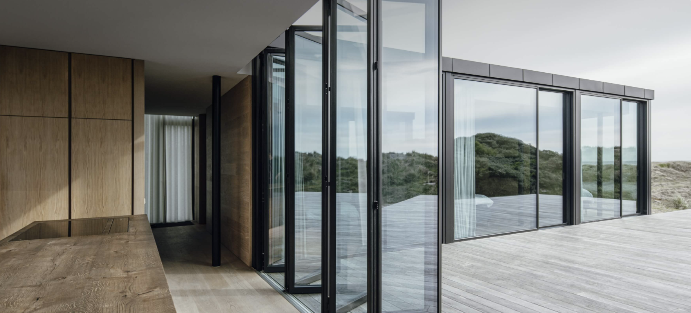 Dark-framed bi-folding doors folded back onto a timber deck