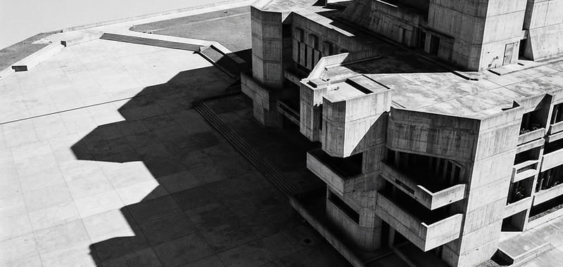 Brutalist concrete structure casting long geometric shadows