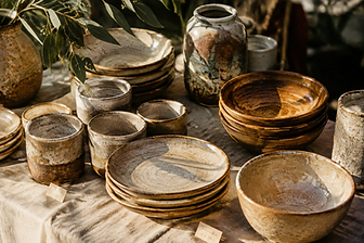 Handmade stoneware and linen displayed on a weathered timber market table