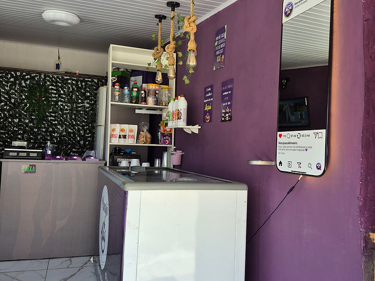 Espelho instagramável em formato de celular iluminado, instalado na parede de um estabelecimento comercial