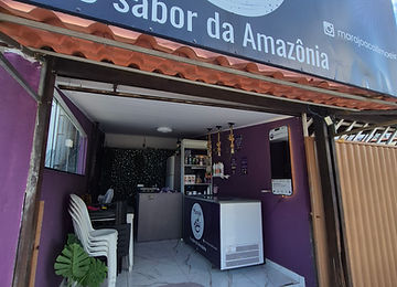 Vista interna do estabelecimento com o espelho instagramável aceso ao fundo do salão