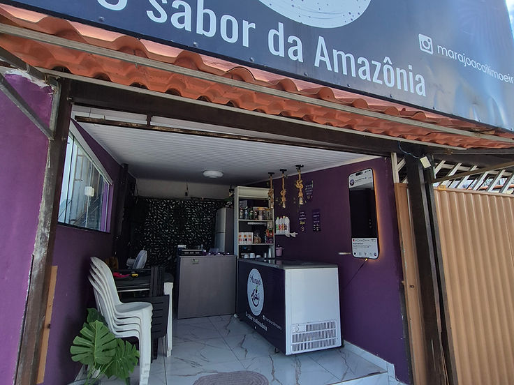 Vista interna do estabelecimento com o espelho instagramável aceso ao fundo do salão