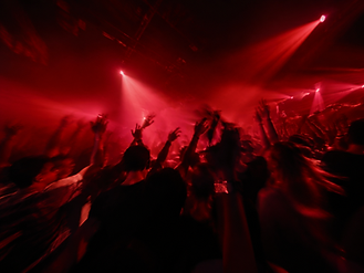 Crowd dancing in deep burgundy light