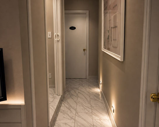 Softly lit hallway leading to Oasis Spa's private treatment rooms