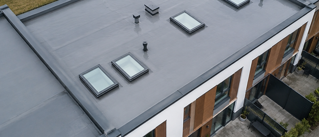 Aerial view of a grey membrane low-slope roof with skylights