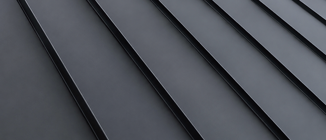 Close-up of aligned charcoal standing seam metal roof panels