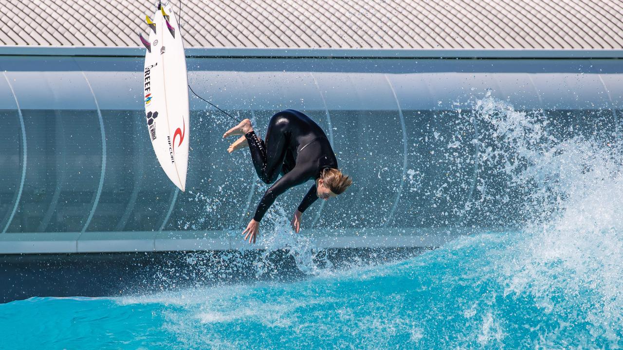 Surfer performing an aerial above a wave