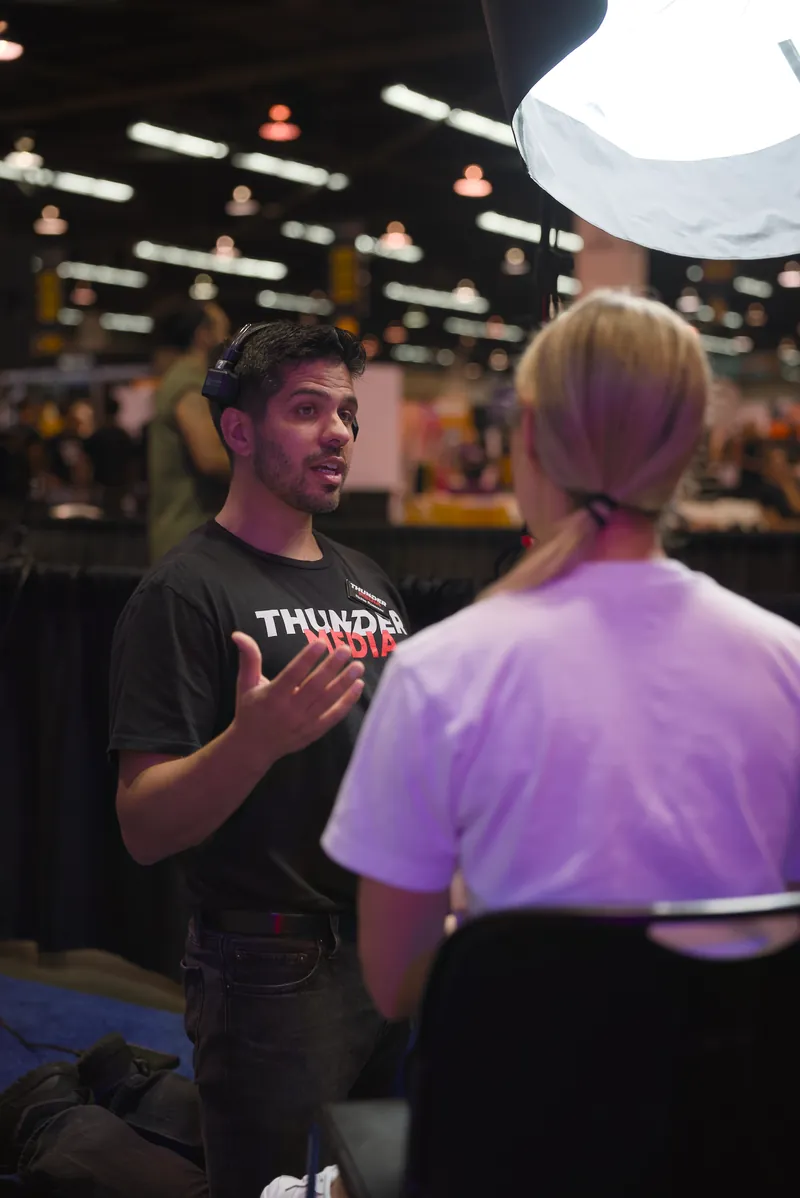 A Thunder Media team member talking with an attendee at an event.