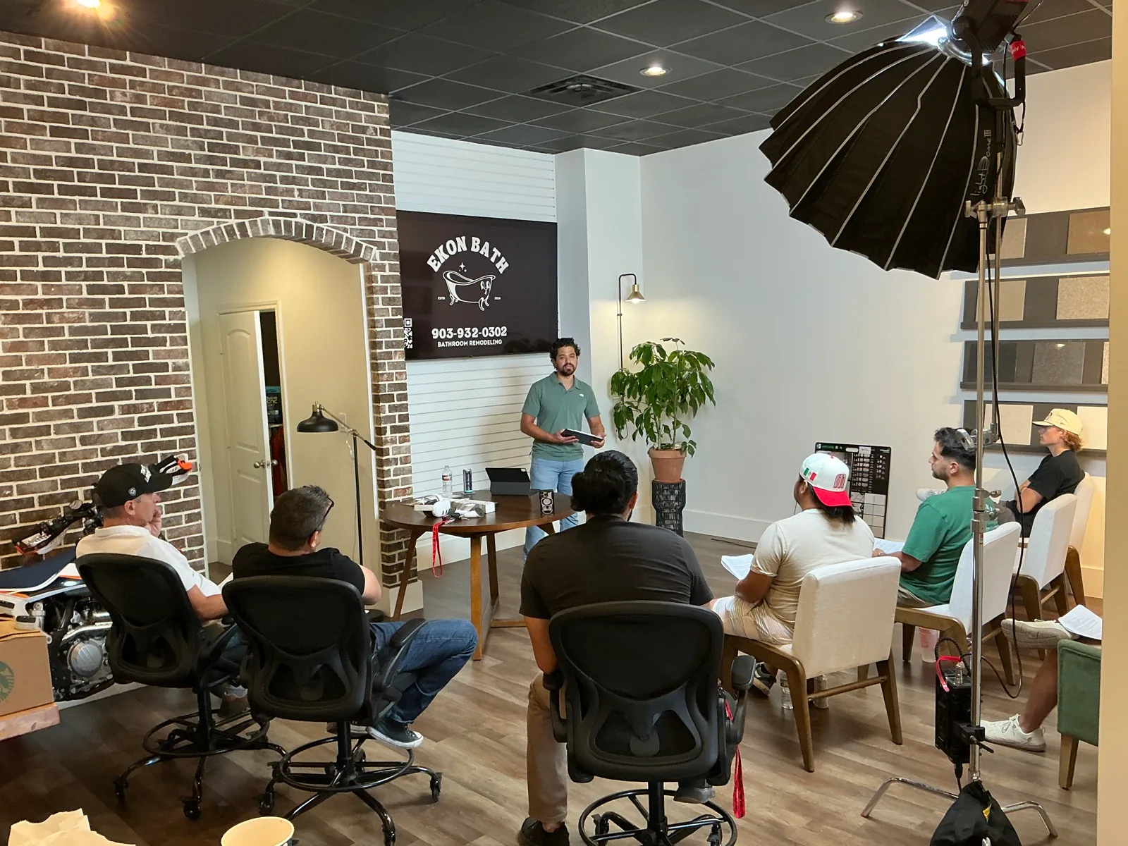 Production lighting and a group gathered beneath the Ekon Bath sign.