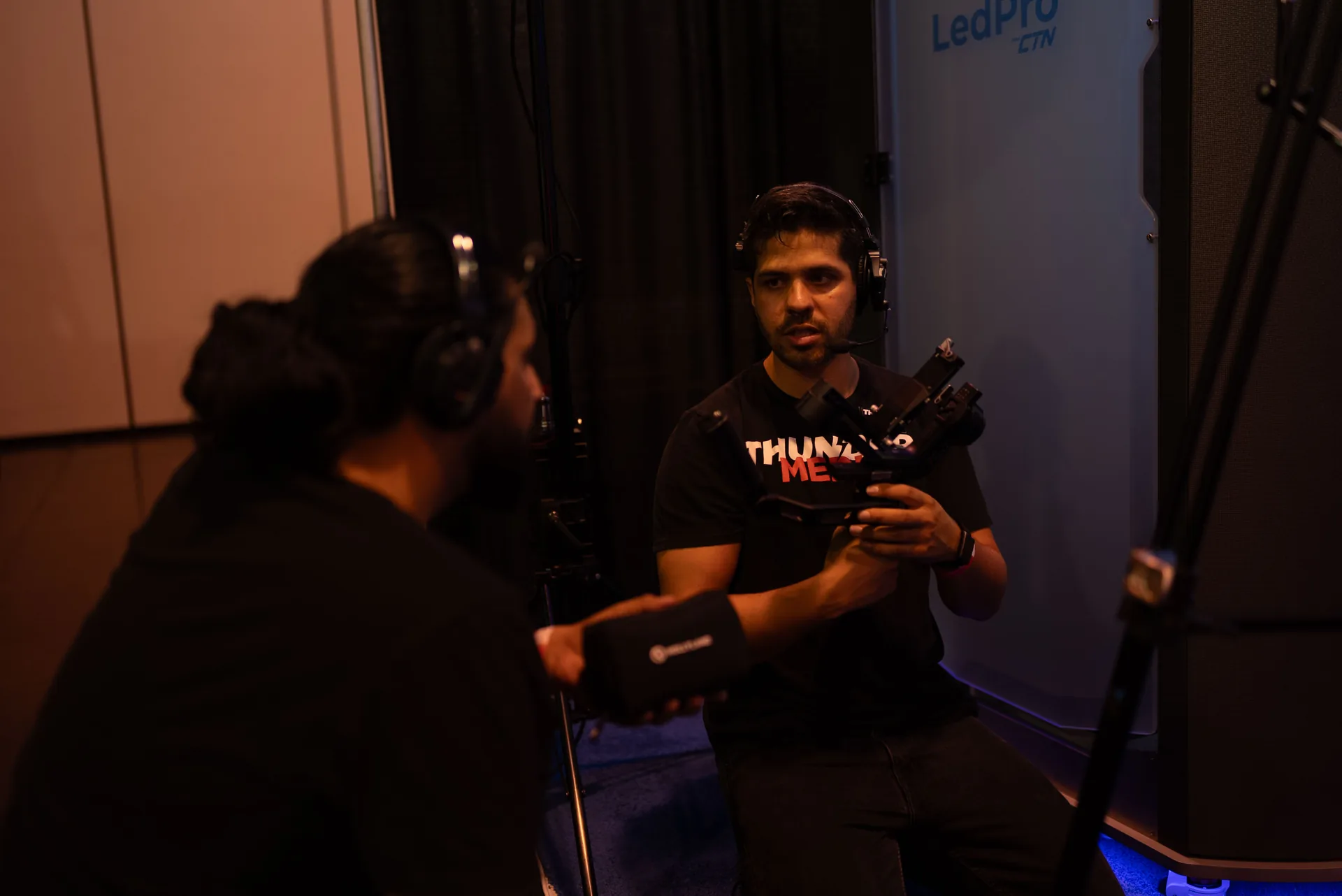 Two Thunder Media crew members wearing headsets and preparing a camera.
