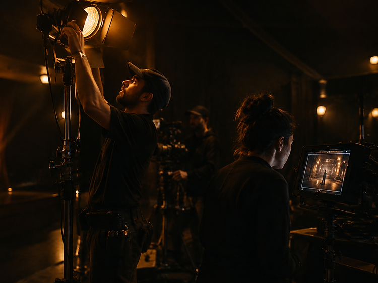 Production crew preparing lighting equipment in a darkened venue