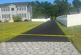Finished asphalt driveway with a granite cobblestone apron