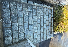 Granite cobblestone apron laid between a driveway and the street