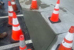 Freshly poured concrete patch cordoned off on a paved lot
