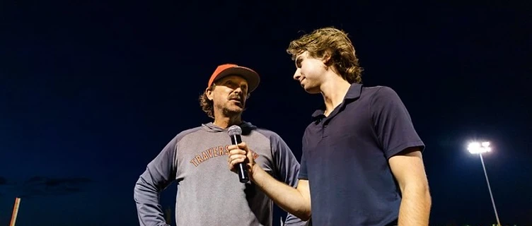 Andrew Henderson interviewing a player postgame under stadium lights