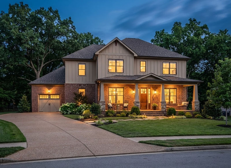 Newly built craftsman home at dusk with warm lit windows in Clarksville, Tennessee
