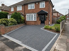 Charcoal herringbone block paving with a lighter edge course