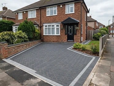 Charcoal herringbone block paving with a lighter edge course