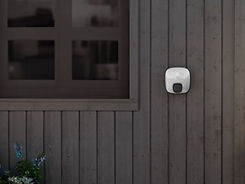 Charge Amps Luna på mörk träfasad vid staket