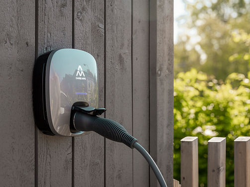 Charge Amps Luna med laddkabel på grå träfasad