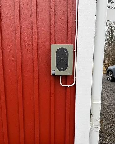 Zaptec Go på röd träfasad