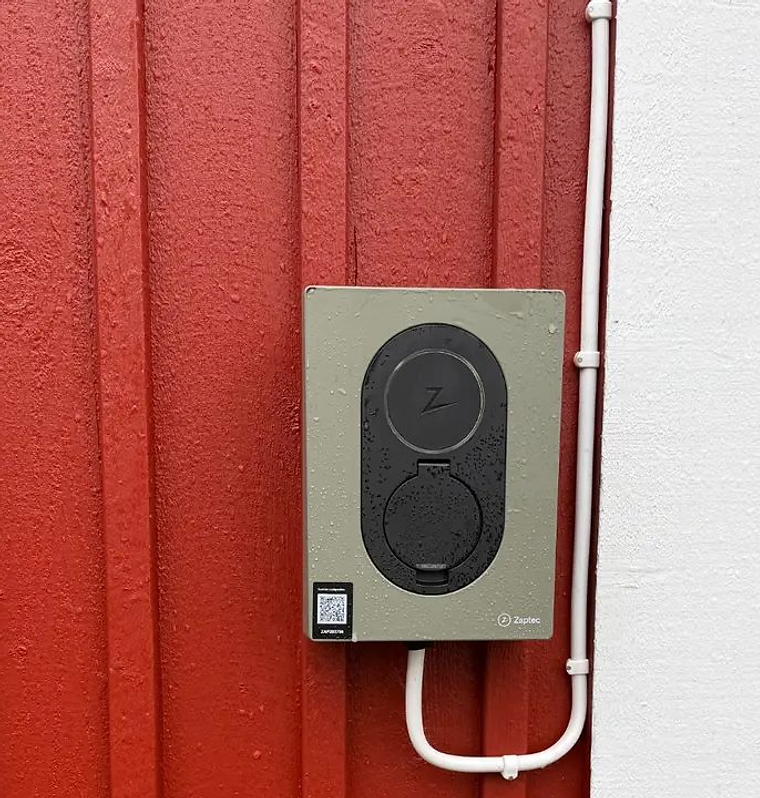 Zaptec Go installerad av Sunnanå Eltjänst på röd träfasad