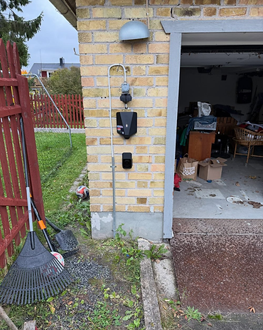 Laddbox på tegelfasad vid garageport