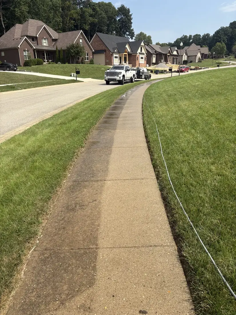 Concrete sidewalk before and after pressure washing, half dirty and half clean