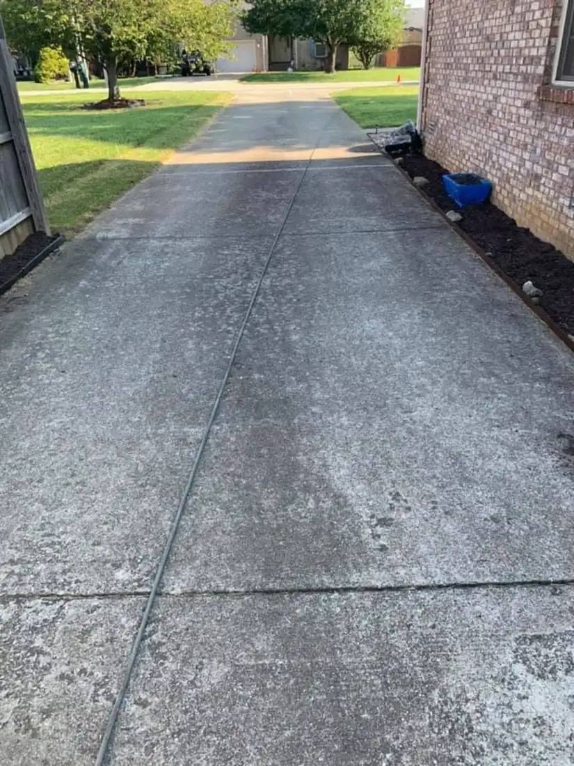 Exposed aggregate driveway before cleaning, dark and grimy