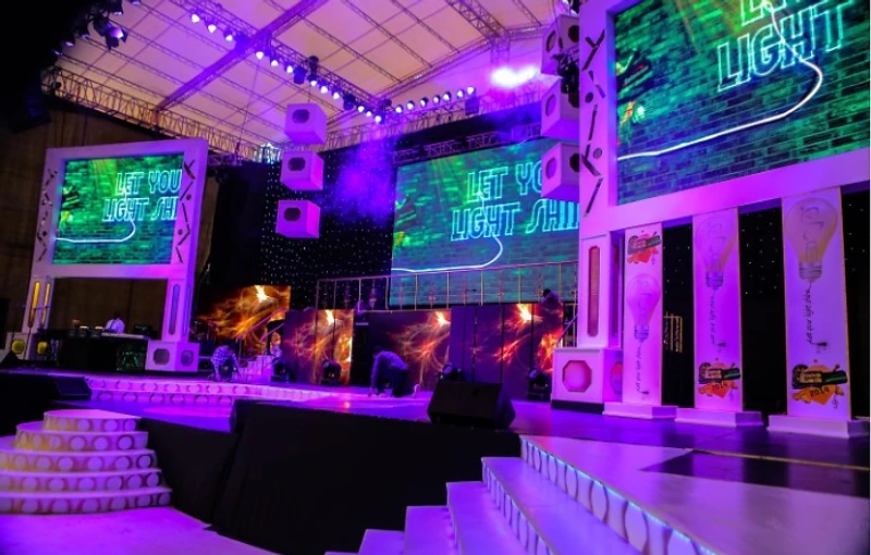 A live THINK & XCITE MARKETING experiential stage with LED walls, lighting rig and audience