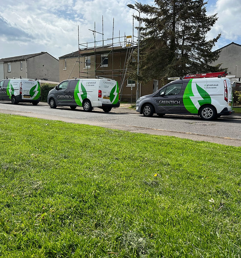 Three Greentech-liveried vans parked on a residential development street