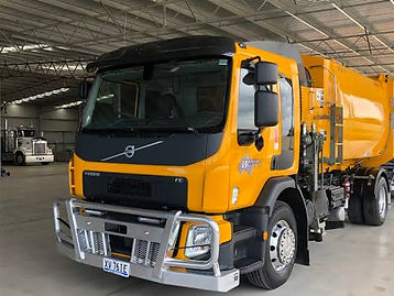 Yellow Volvo FE waste collection truck inside the shed