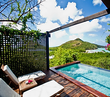 A private pool and sun loungers overlooking a green island and turquoise sea