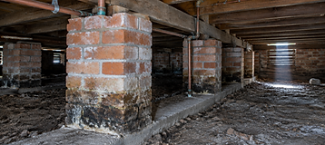 Brick piers and timber bearers inside the subfloor of an older Australian house