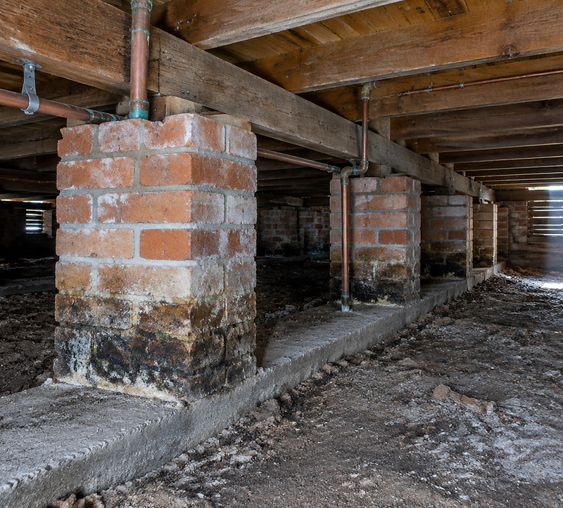 Brick piers and timber bearers inside the subfloor of an older Australian house
