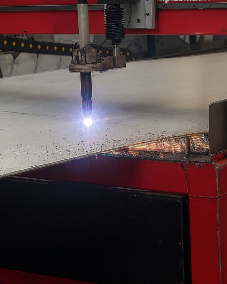Antorcha de plasma cortando placa de acero con chispas en el taller de MAQUILAS MEYAR