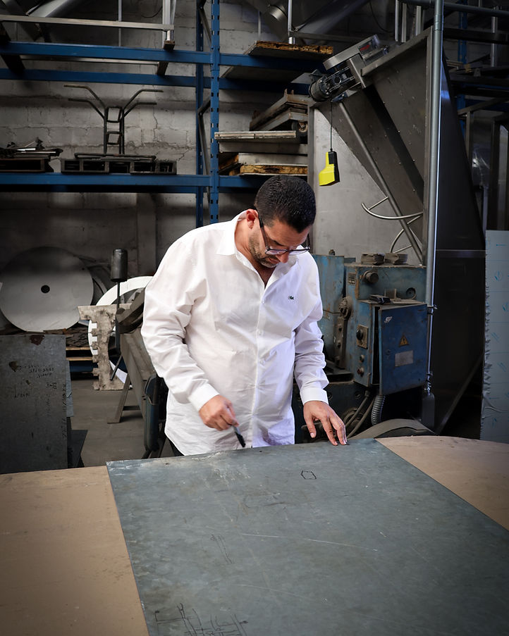 Diseñador marcando las medidas de una pieza metálica en el taller de MAQUILAS MEYAR
