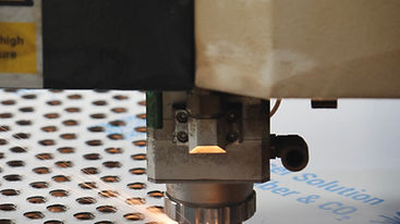 Cabezal de corte láser CNC cortando placa de acero con chispas en el taller
