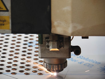 Cabezal de corte láser CNC cortando placa de acero con chispas en el taller