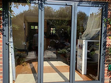 Bifold doors after: three-panel anthracite bifold installed in the brick opening