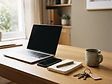 A desk in a property management office with a laptop, phone and notebook