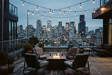 Rooftop amenity deck of an apartment community at dusk with empty lounge seating and string lights