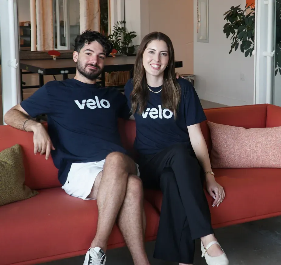 Velo co-founders, Base44 Accelerator participants, sitting together on a red couch