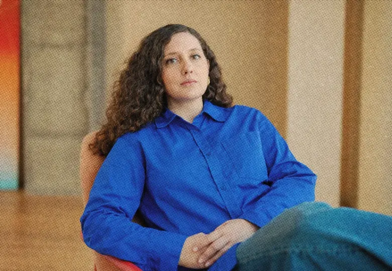 Portrait of an employee in a blue shirt on an orange chair