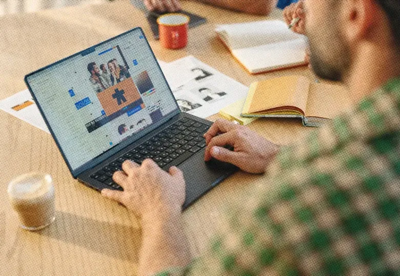 An employee in a plaid shirt working on his laptop