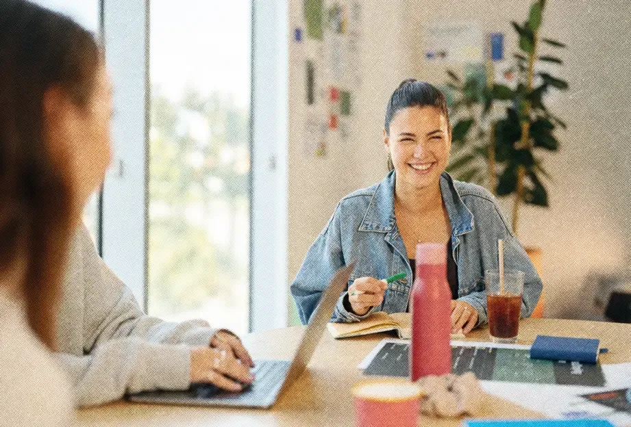 A teammate smiling across the table during a meeting